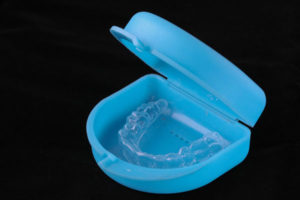 A blue plastic case with a clear retainer inside