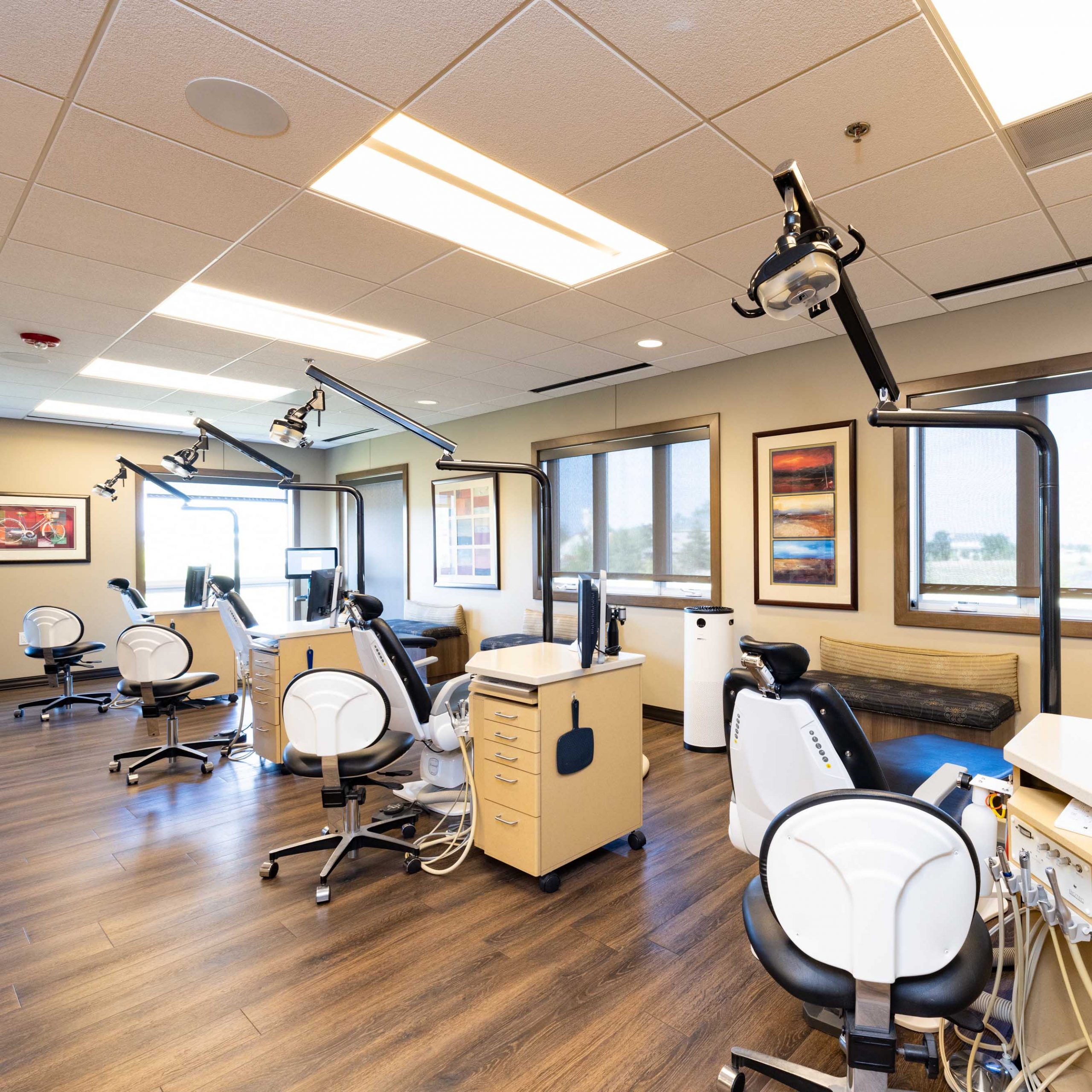 Dental office treatment area with chairs and lights.